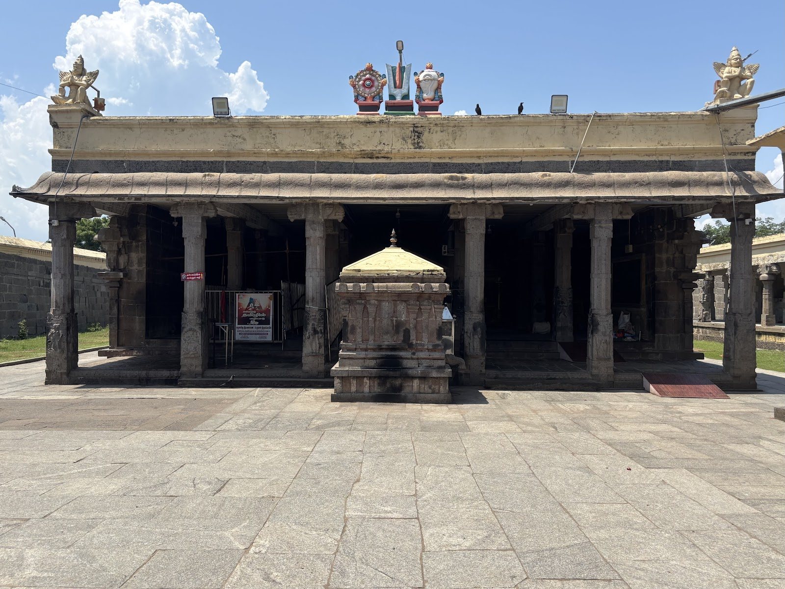 Granite gopuram tower and ancient stone pillars at Nithya Kalyana Perumal Temple in Thiruvidandhai