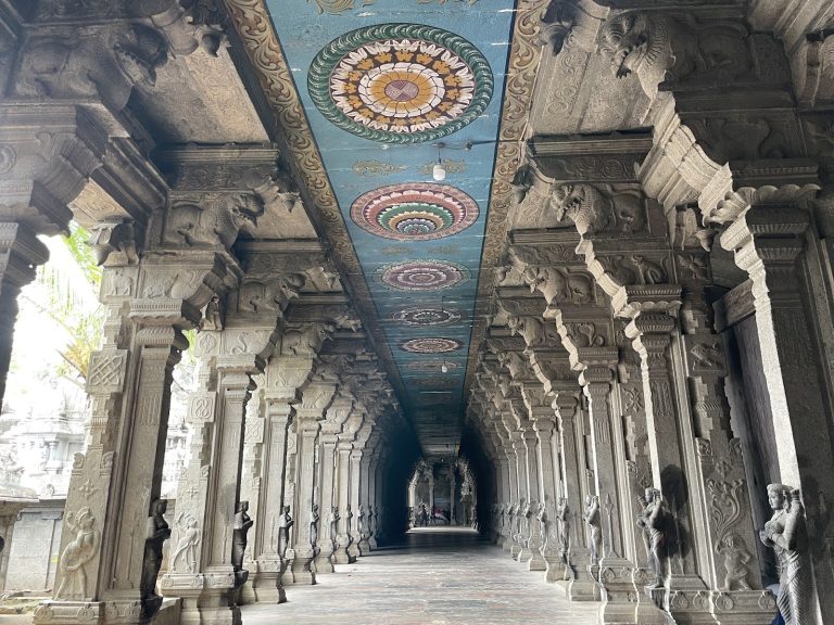 The tall white gopuram gateway of Suchindram Thanumalayan Temple against a clear blue sky